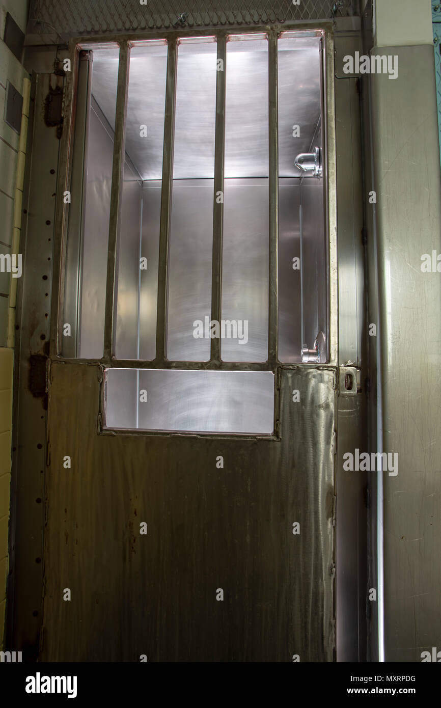 Steel door with bars on shower stall inside old prison hospital wing. Stock Photo