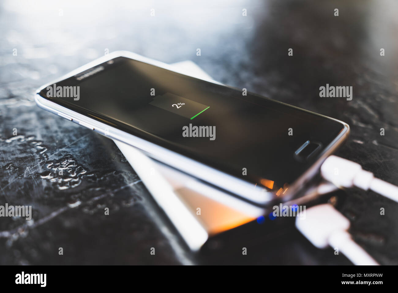 Bangkok, Thailand - May 24, 2018: Samsung Galaxy S7 Edge smartphone charging power via powerbank battery charger. Illustrative editorial image. Stock Photo