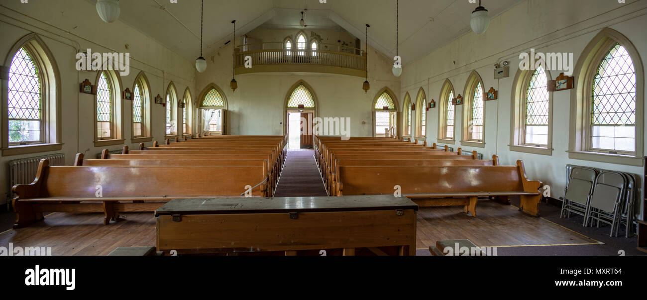 Interior of abandoned church with wooden pews inside prison yard. Stock Photo