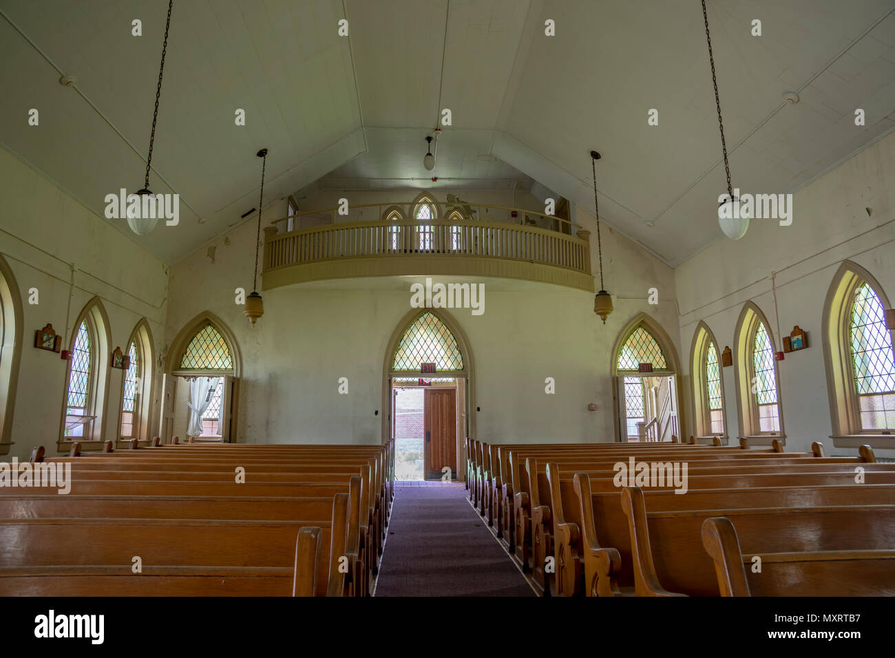 Interior of abandoned church with wooden pews inside prison yard. Stock Photo