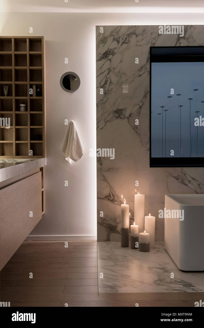 Illuminated modern bathroom with white wall and a parquet on the floor