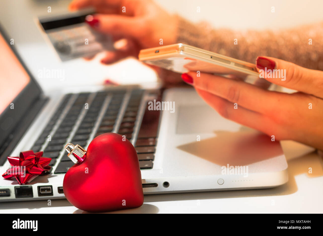 Woman shopping online during christmas holiday with credit card and smart phone Stock Photo
