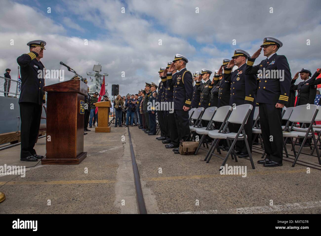 161206-N-VN584-484 SAN DIEGO (Dec. 6, 2016) Officers from U.S. 3rd Fleet salute the ensign as the national anthem is played by the U.S. Navy band on B Street Pier for the arrival of the People’s Liberation Army (Navy). Rear Adm. Jay Bynum, commander of Carrier Strike Group Nine, is hosting three PLA(N) ships during a routine port visit in San Diego.  (U.S. Navy photo by Seaman Alex Corona/Released) Stock Photo