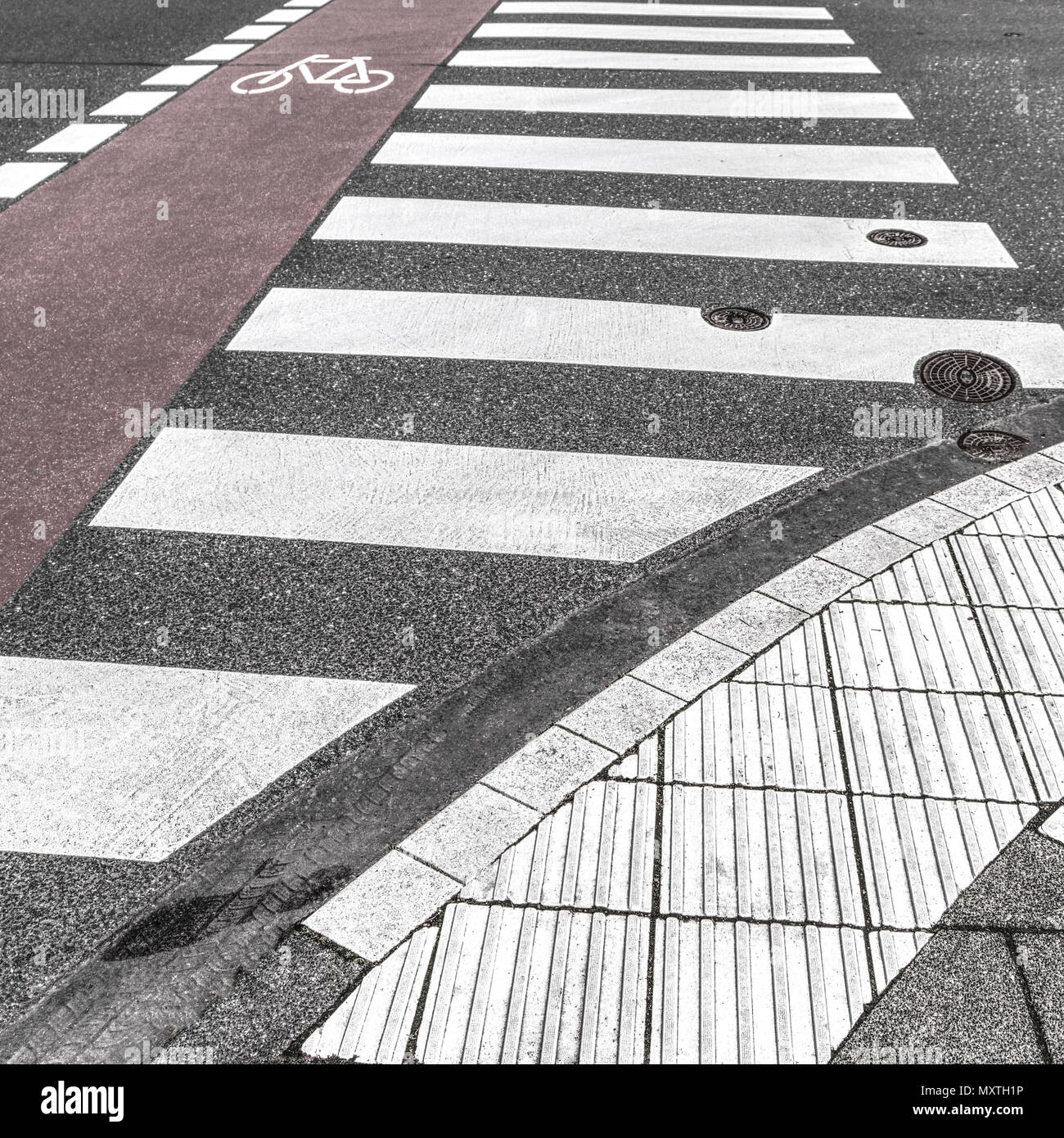 Pedestrian crossing. Überweg auch Zebrastreifen genannt mit Radweg und fühlbaren Markierungen für Sehbehinderte Stock Photo