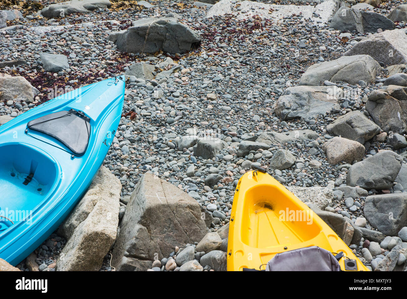 Two kayaks tied down on the rocky beach. Stock Photo