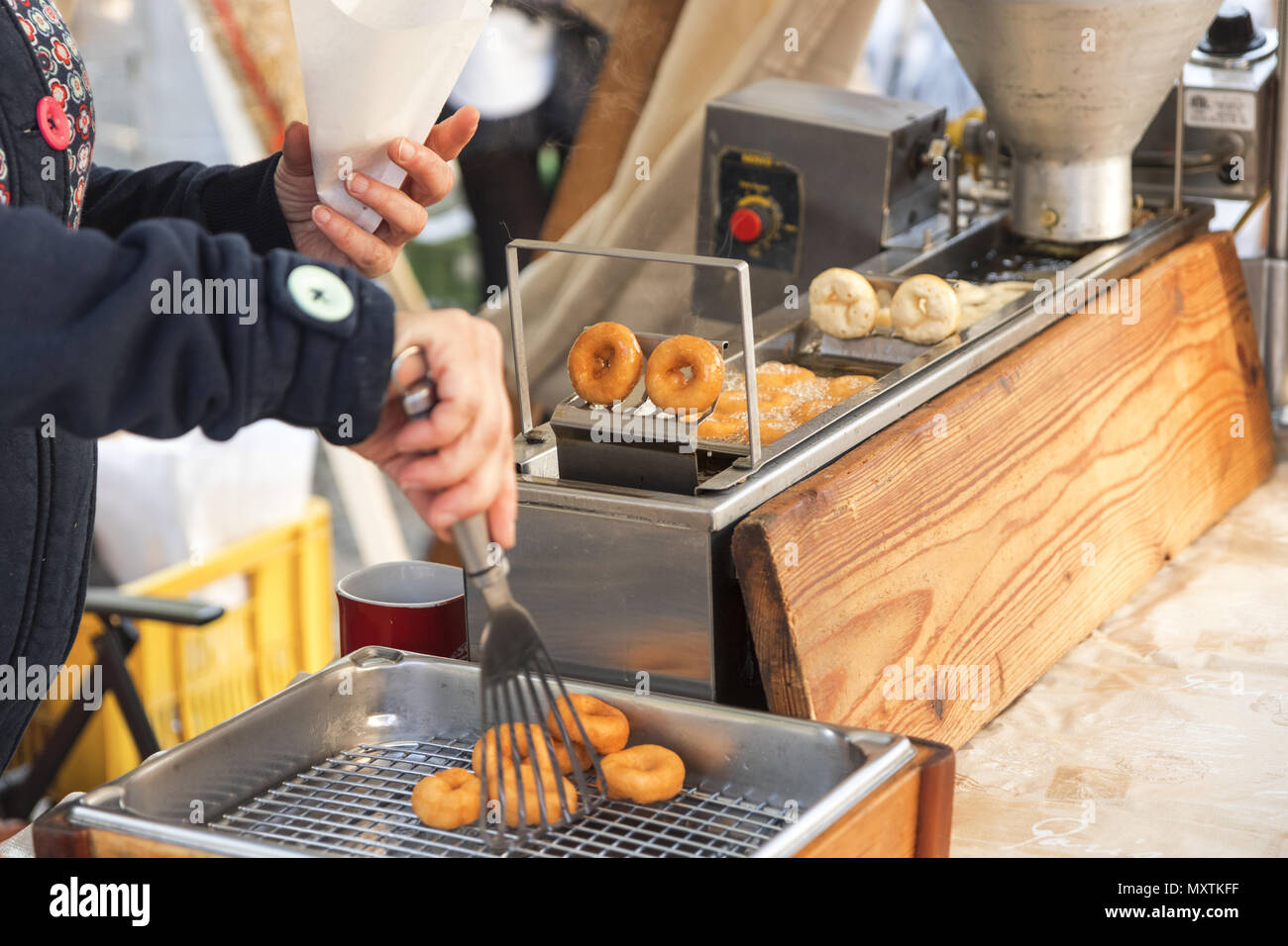 Street food market. Vendors at the street market make fresh donuts