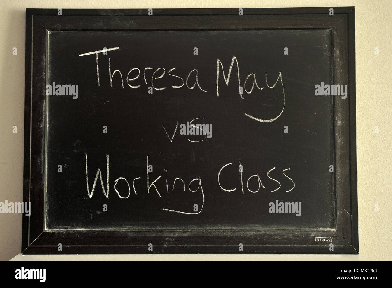 Theresa May vs working class written in white chalk on a blackboard. Stock Photo