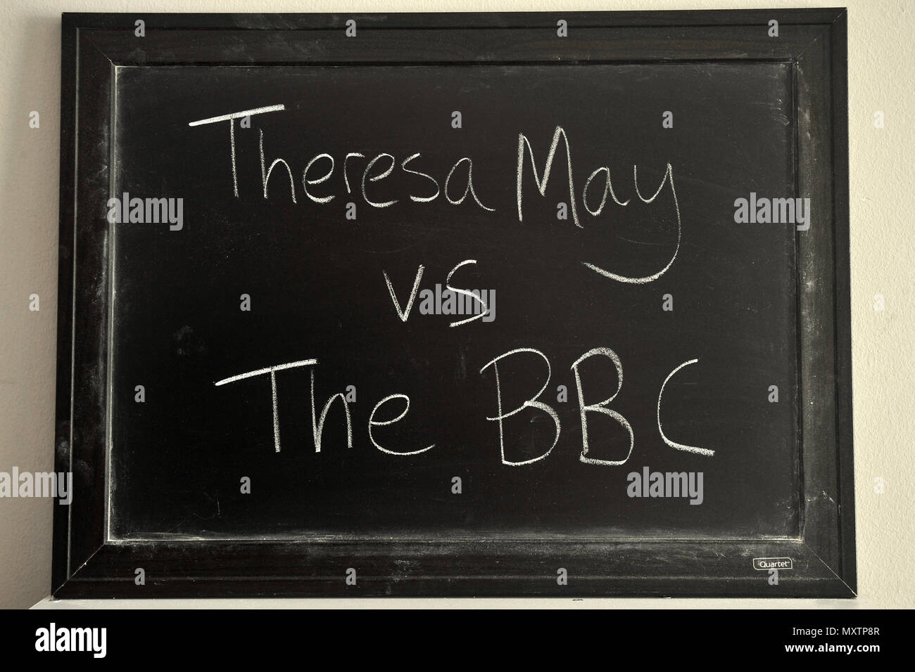 Theresa May vs The BBC written in white chalk on a blackboard. Stock Photo