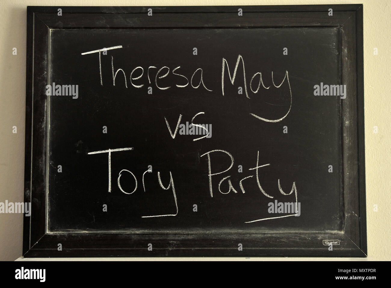 Theresa May vs Tory Party written in white chalk on a blackboard. Stock Photo