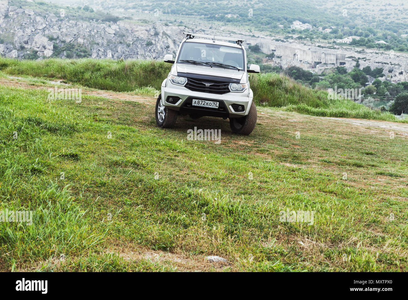 Sevastopol, Crimea - May 7, 2018: Silver gray UAZ Patriot stands on grass in mountains. UAZ-3163, mid-size SUV produced by UAZ division of SeverstalAv Stock Photo