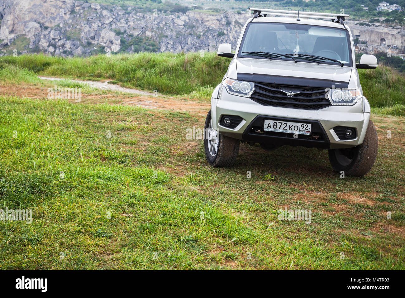 Sevastopol, Crimea - May 7, 2018: UAZ Patriot stands on grass in mountains. UAZ-3163, mid-size SUV produced by UAZ division of SeverstalAvto in Ulyano Stock Photo