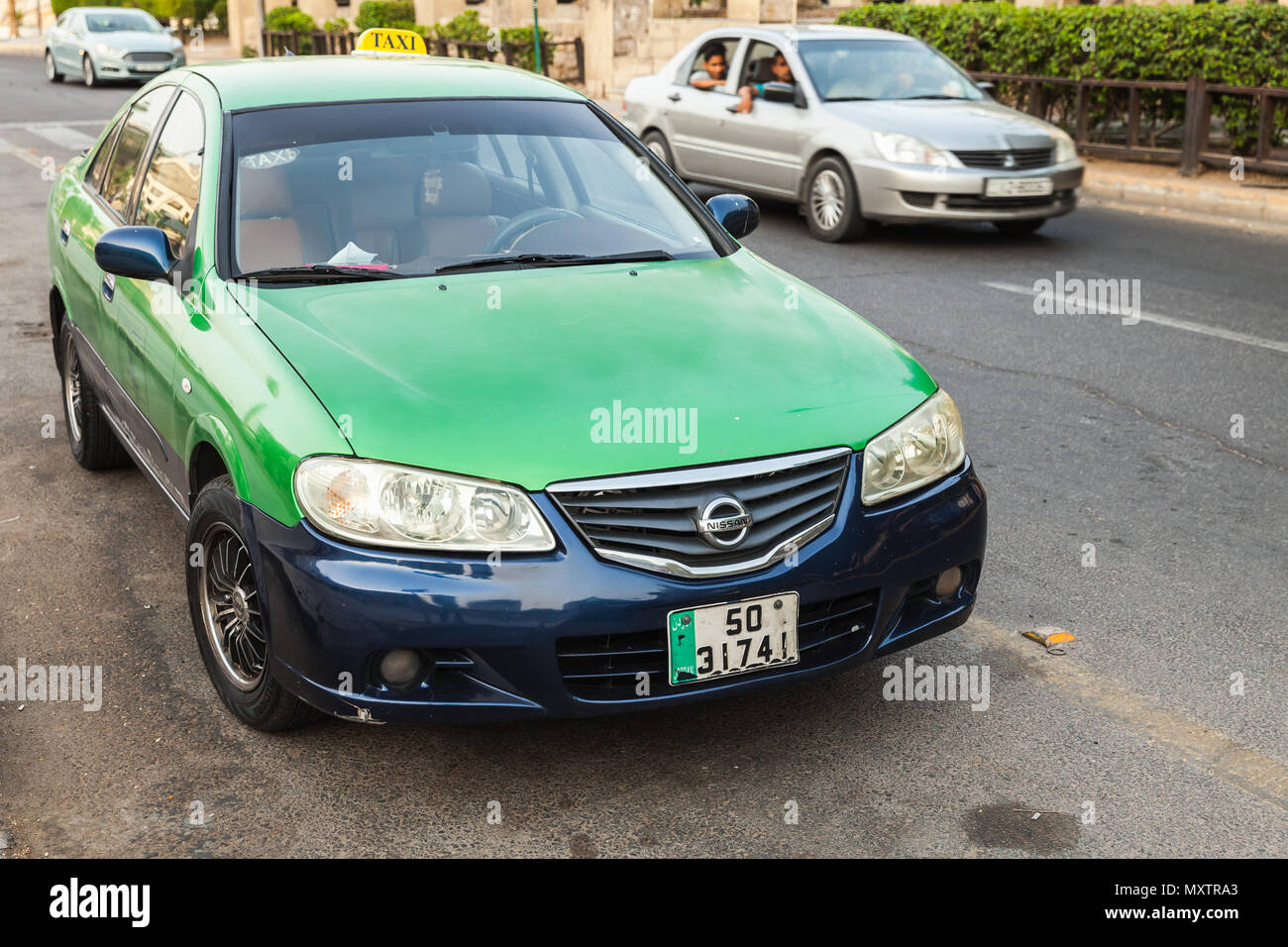 Aqaba, Jordan - May 18, 2018: Green Nissan car of Wadi Rum taxi company stands parked on a street side in Aqaba city Stock Photo