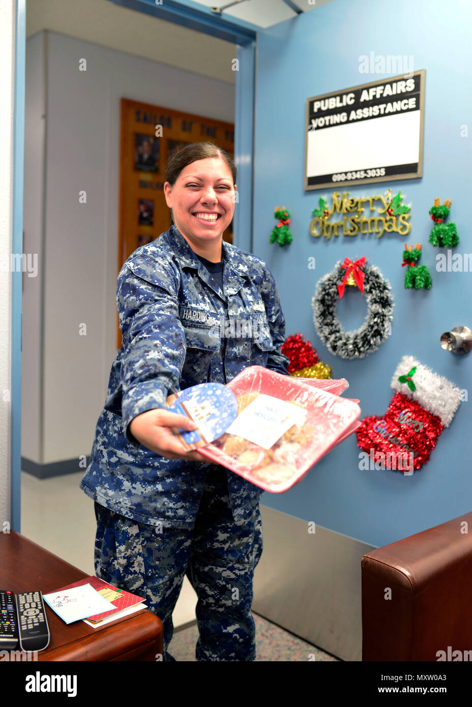 161207-N-OK605-021 MISAWA, Japan (Dec. 7, 2016) Petty Officer 2nd Class Raven Harding hands out packages of cookies for the 2016 Cookie Caper at Misawa Airbase. Hundreds of volunteers made over 36,000 cookies and packaged them into 3,000 gifts to give to single unaccompanied Servicemembers stationed at Misawa Airbase for the holidays. (U.S. Navy Photo by Petty Officer 2nd Class Samuel Weldin/Released) Stock Photo