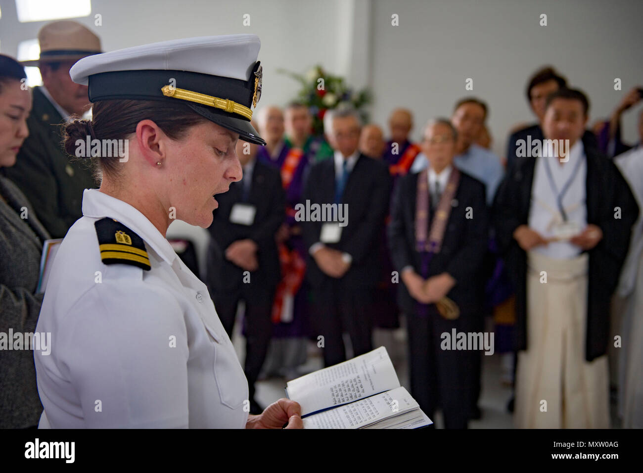 161206-N-YW024-054 PEARL HARBOR (Dec. 6, 2016) Lt. Emily Rosenzweig, a chaplain assigned to 3rd Radio Battalion Religious Ministry Team at Marine Corps Base Hawaii, reads a Hebrew prayer aboard the USS Arizona Memorial during an Interfaith Prayer service and Floral Tribute. The event allowed religious leaders from the U.S. military, Hawaii, and Japan to engage in prayer to honor the fallen service members. Dec. 7, 2016, marks the 75th anniversary of the attacks on Pearl Harbor and Oahu. Since Dec. 7, 1941, the U.S. and Japan have endured more than 70 years of continued peace, a cornerstone of  Stock Photo