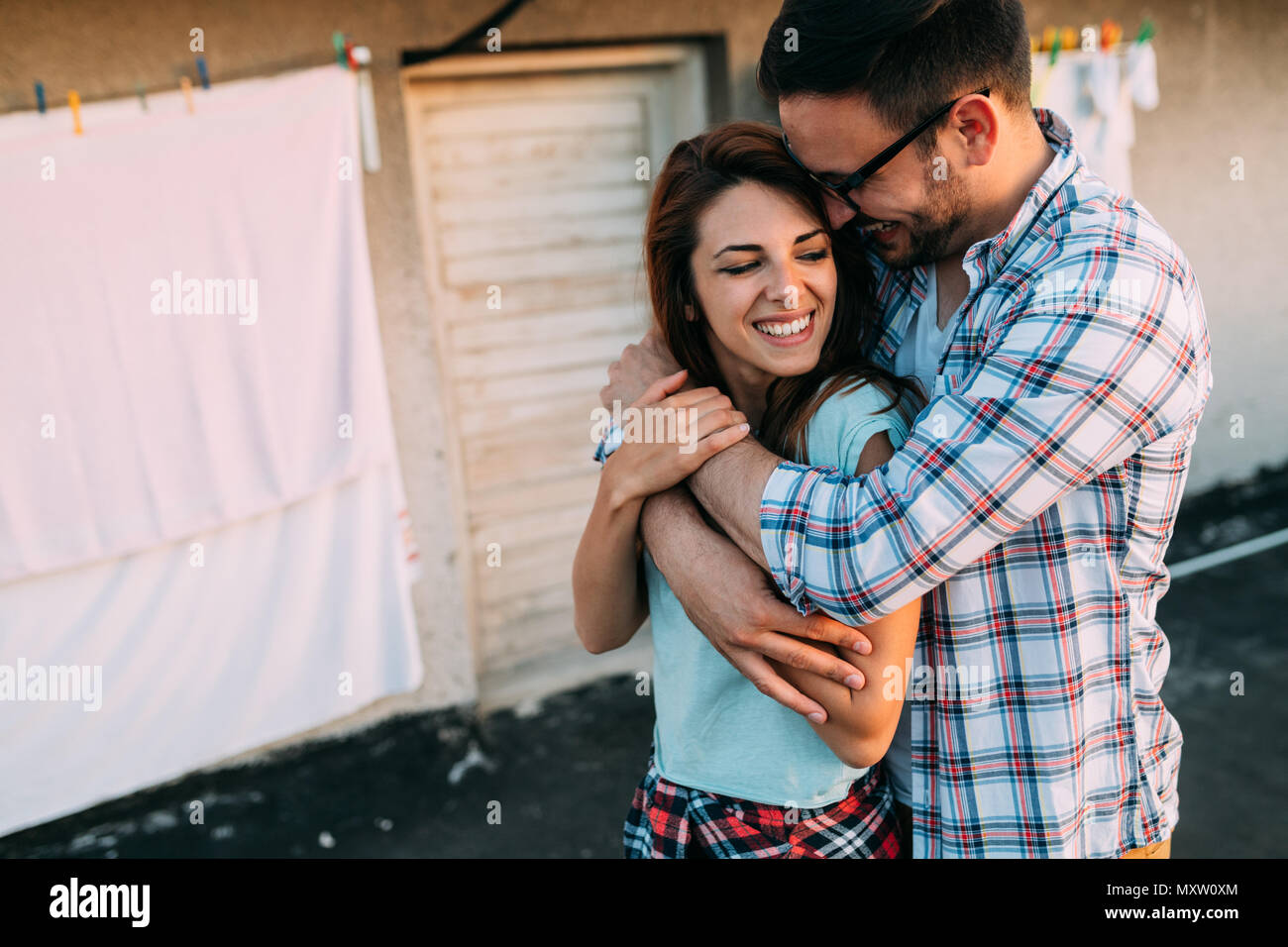 Portrait of a loving young man embracing woman from behind Stock Photo ...