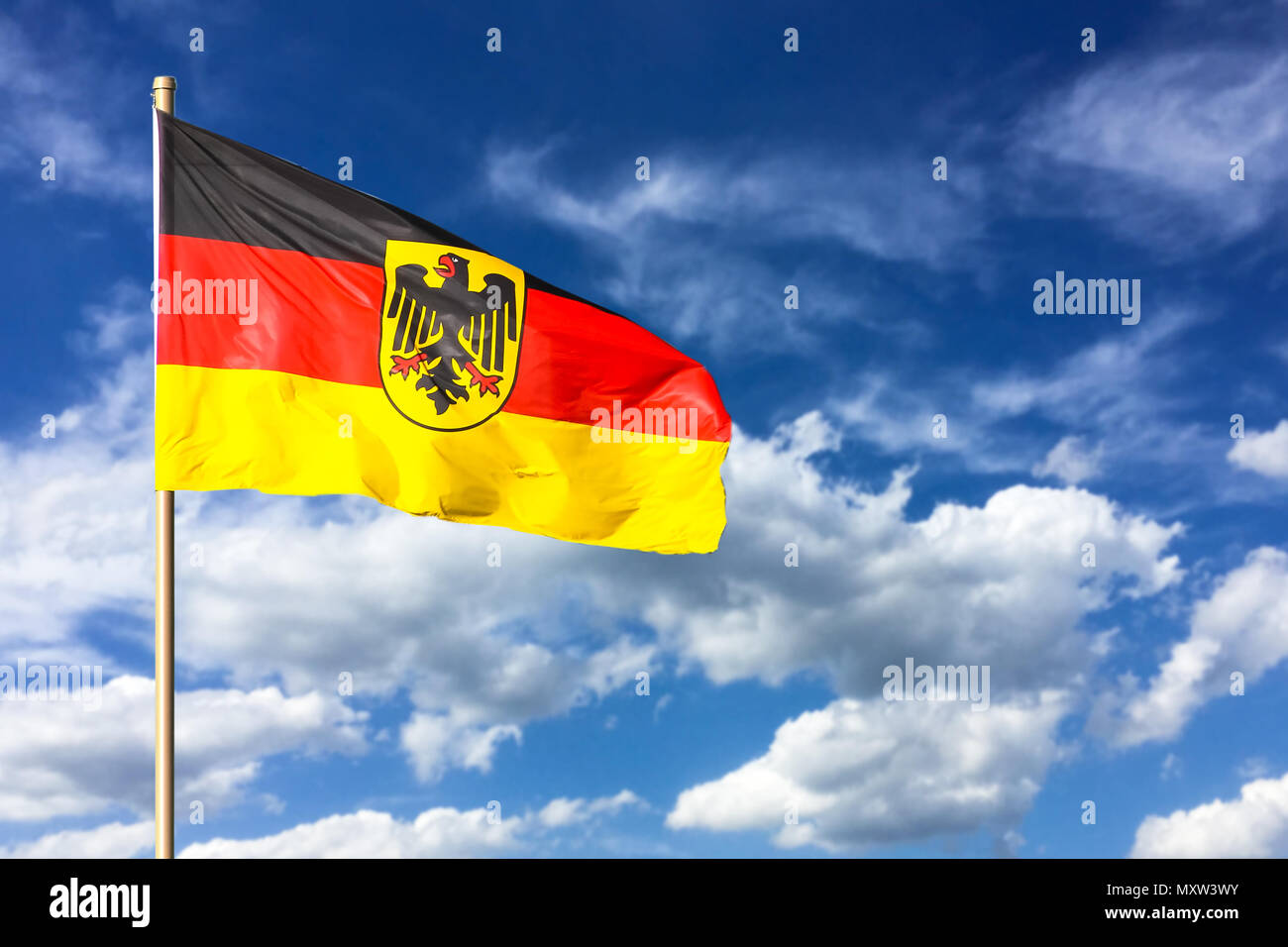 Flag of Germany (Federal Republic of Germany; in German: Bundesrepublik Deutschland) waving in the wind on a bright sunny summer day and blue sky back Stock Photo