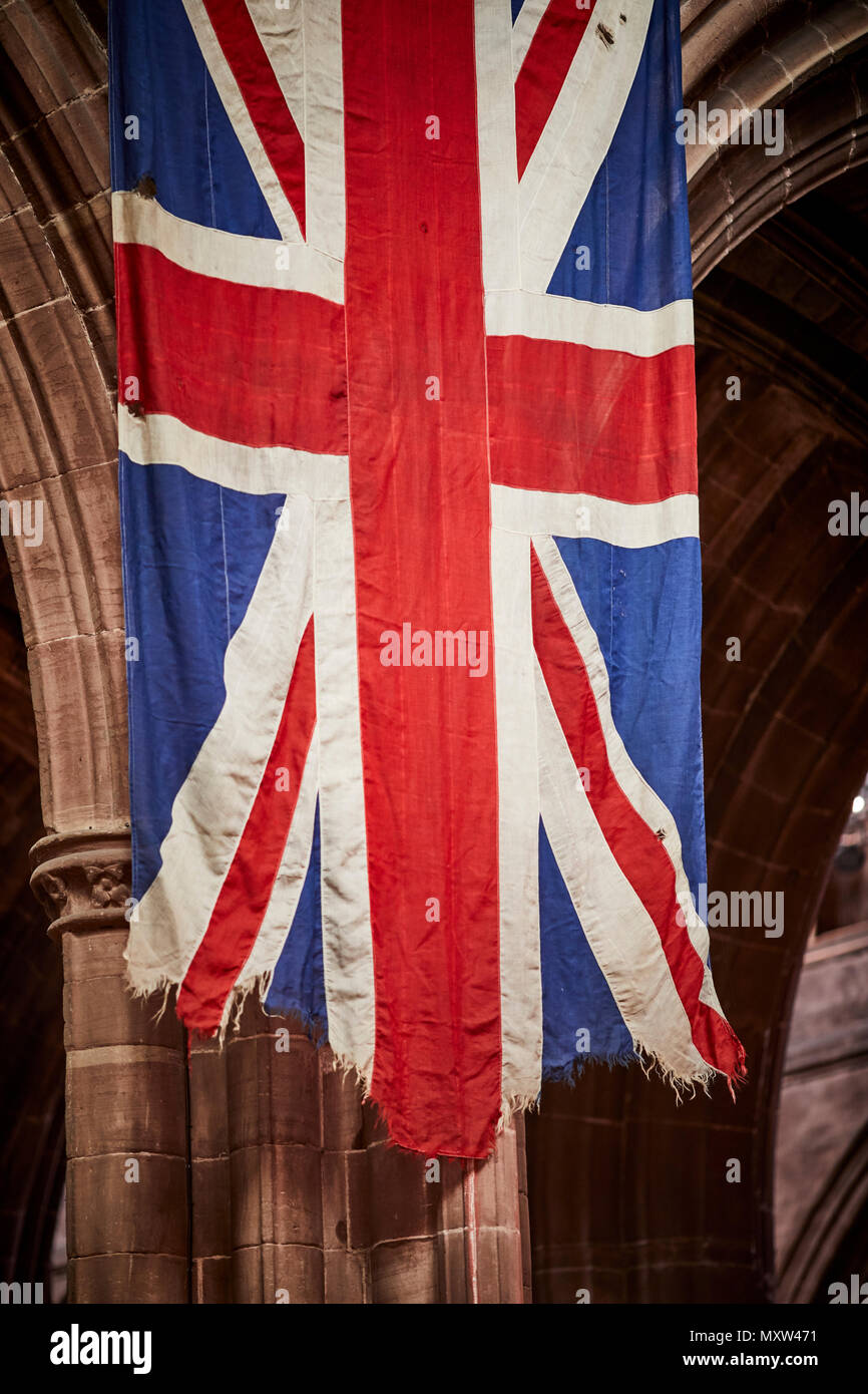Chester Cathedral a torn hanging  The Union Jack or Union Flag the national flag of  United Kingdom Stock Photo