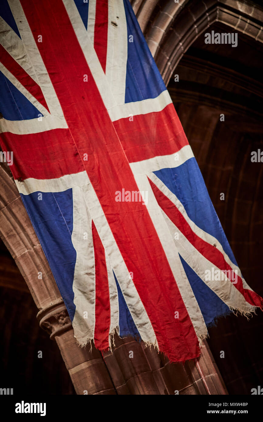 Chester Cathedral a torn hanging  The Union Jack or Union Flag the national flag of  United Kingdom Stock Photo