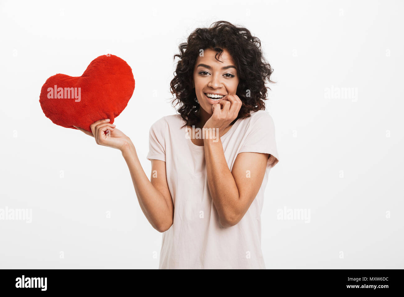 Portrait of lovely woman 20s with brown hair holding red paper heart ...