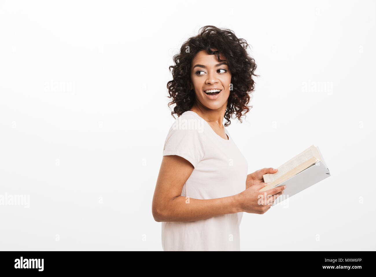 Portrait of a happy young afro american woman holding opened book and ...