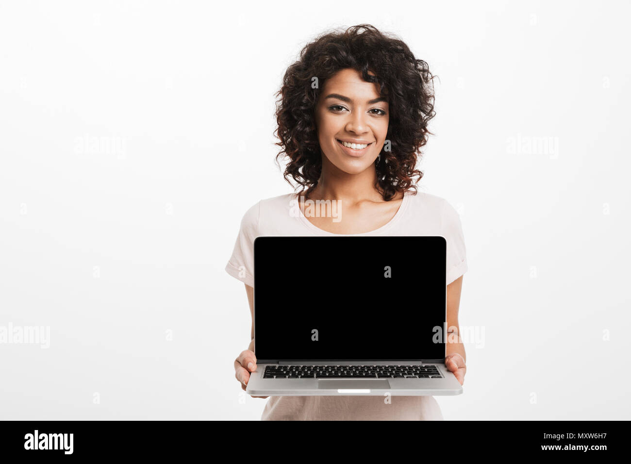 Portrait of happy young afro american woman showing blank screen laptop ...