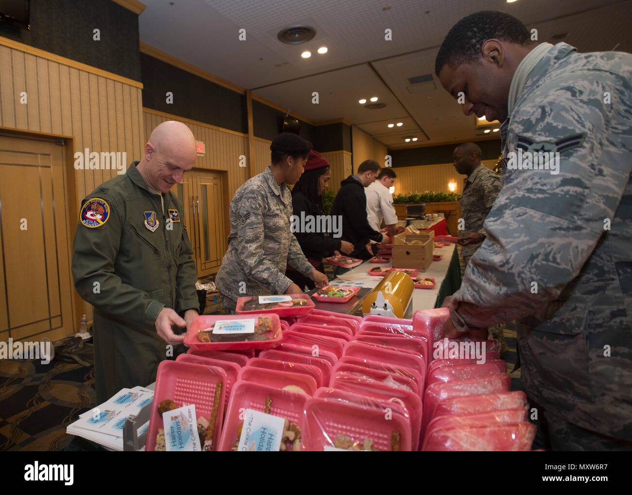 U.S. Air Force Col. R. Scott Jobe, 35th Fighter Wing commander, assists Airmen package cookies during the annual Cookie Caper event at Misawa Air Base, Japan, Dec. 7, 2016.  Preparation began two days prior when volunteers baked donated dough at the Commissary and collected baked cookies from around the Misawa community for packaging. (U.S. Air Force photo by Senior Airman Deana Heitzman) Stock Photo