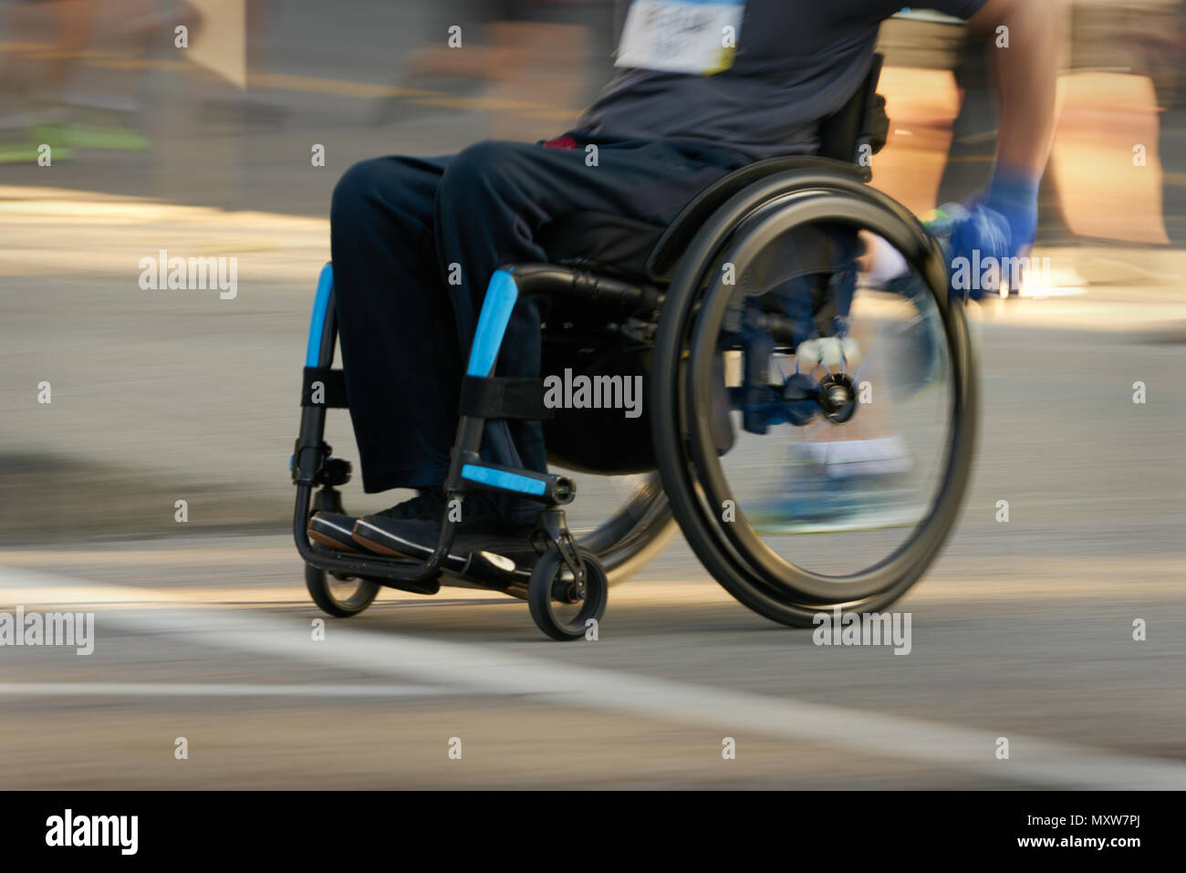 Racing in a Wheelchair  Competitor using a wheelchair in a race. Motion blur. Stock Photo