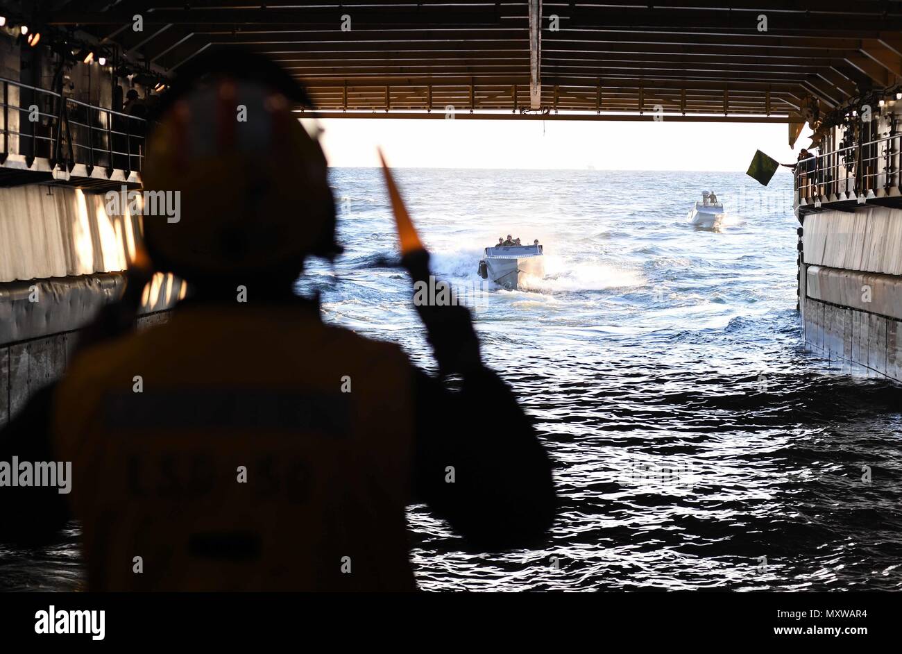 161209-N-ME988-712 ATLANTIC OCEAN (Dec. 09, 2016) – Sailors aboard the amphibious dock landing ship USS Carter Hall (LSD 50) direct Special Warfare Combatant-craft Crewmen (SWCC) with Special Boat Team (SBT) 20 into the ship’s well deck. The team practiced mooring and maneuvering their craft inside the ship’s well deck. Carter Hall is underway with the Bataan Amphibious Readiness Group (ARG) participating in ARG/Marine Expeditionary Unit Exercise (ARG/MEUEX). (U.S. Navy photo by Petty Officer 1st Class Darren M. Moore/Released) Stock Photo