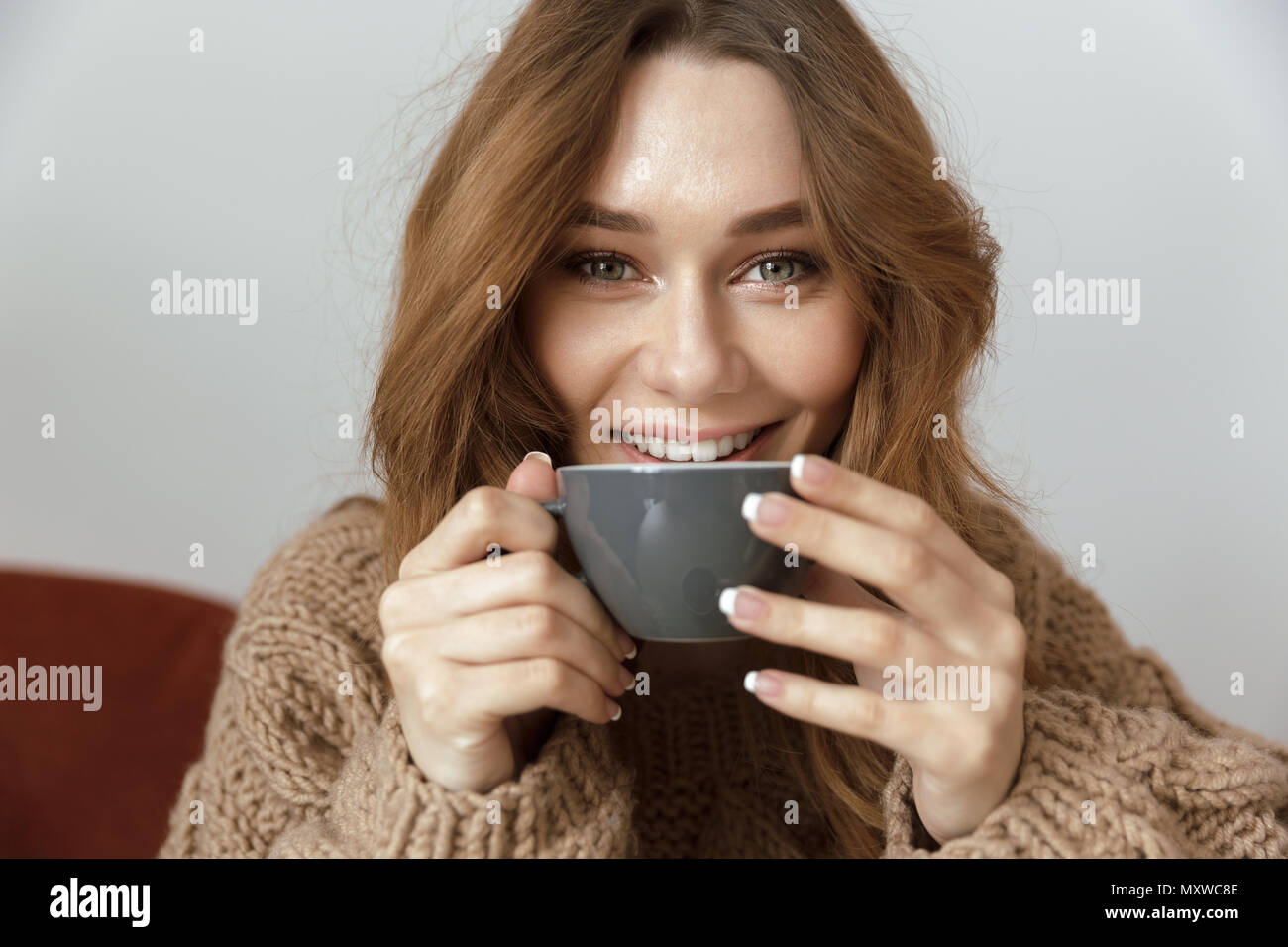 Photo of satisfied and relaxed woman resting at home in living room and