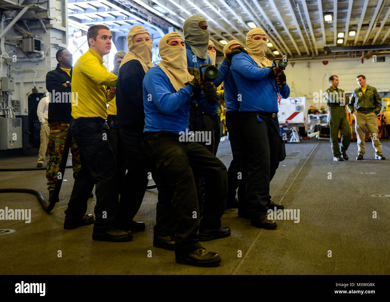 ATLANTIC OCEAN (Dec. 11, 2016) – Sailors man fire hoses during a general quarters drill in the hangar bay of amphibious assault ship USS Iwo Jima (LHD 7). Iwo Jima is underway pursuing Mobility-Engineering (MOB-E) and Mobility-Seaman (MOB-S) certifications as part of the ship’s pre-deployment qualification process. (U.S. Navy photo by Seaman Kevin Leitner/Released) Stock Photo