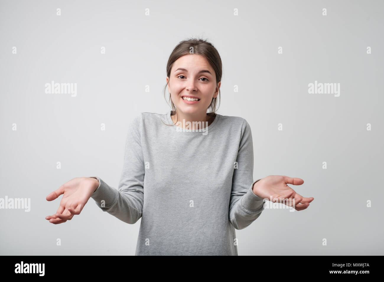 I don't know. Confused cute caucasian girl looking at camera. Stock Photo