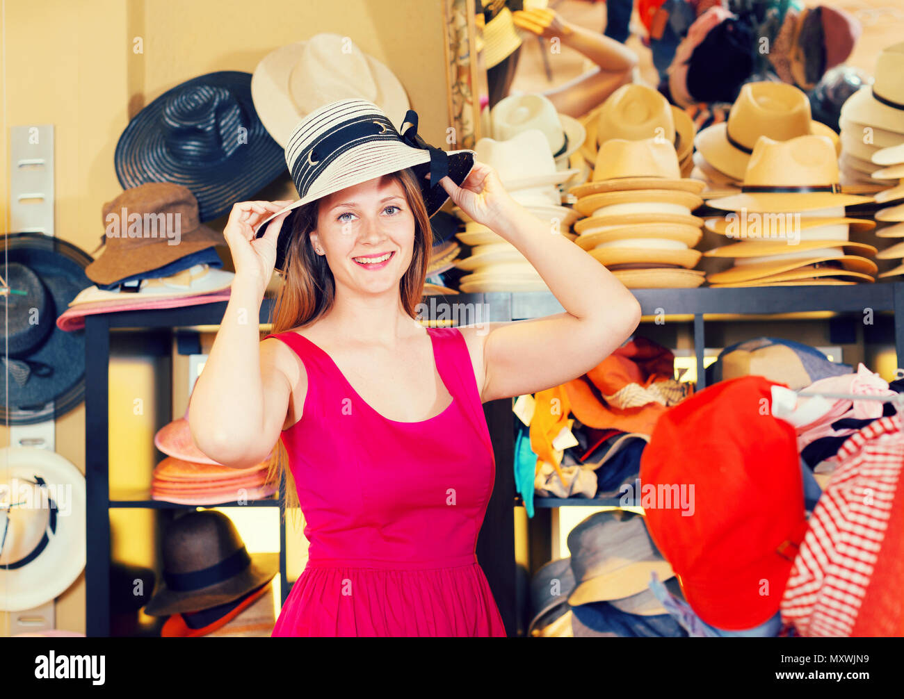 Примерять шляпу. Женщина примеряет шляпу. Примерка шляпки. Девушка примеряет шляпку. Примерка головных уборов в торговом центре.