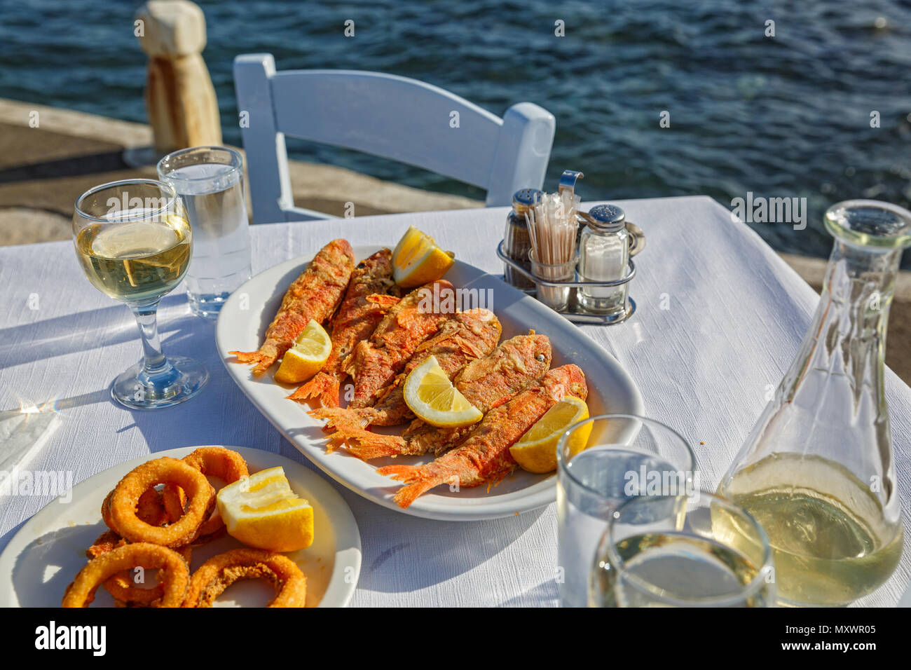 Grilled fish and squid rings in a restaurant on the beach Stock Photo ...