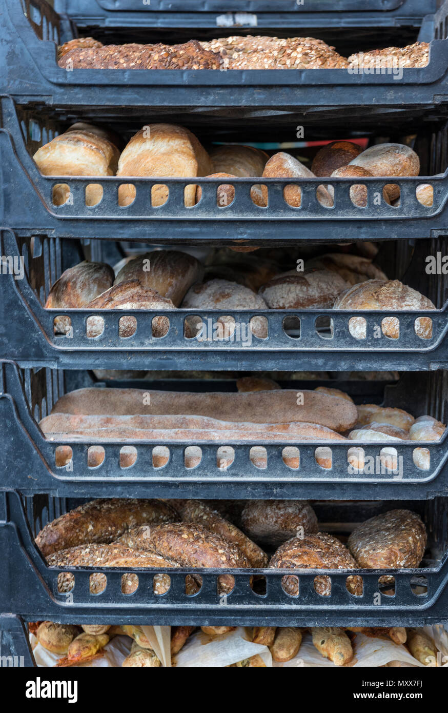 trays of freshly baked breads at an artisan bakers stall at a market in central London. borough market bakery stall and fresh rolls and loaves. Stock Photo