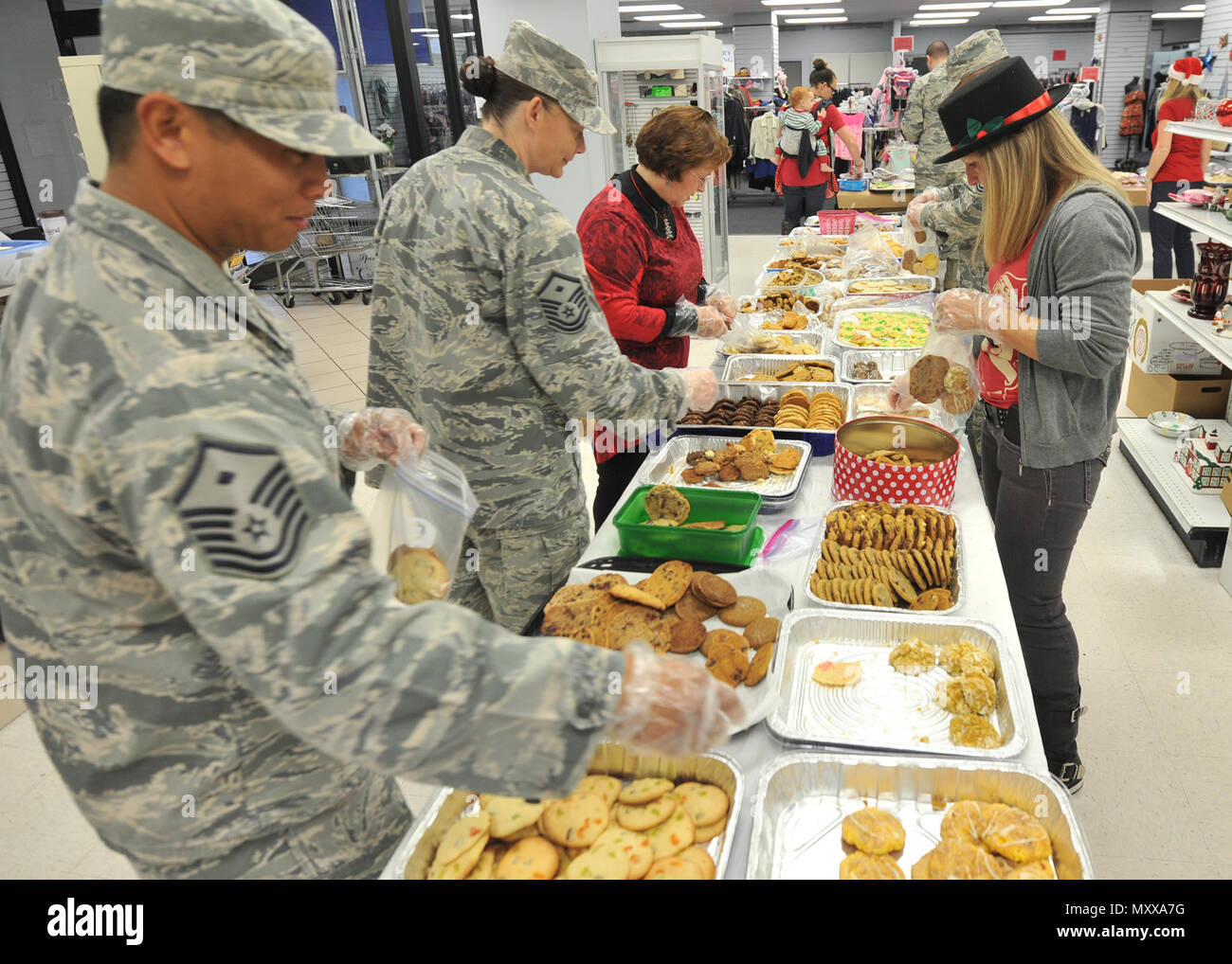 Members of the Tyndall Spouses Club, Tyndall First Sergeants Association and other volunteer Airmen bag cookies in preparation for the Cookie Caper at the thrift shop on Tyndall Air Force Base, Fla., Dec. 12, 2016. The event is intended to reach out to single Airmen who are away from home and may not be able to spend time with family. (U.S. Air Force photo by Senior Airman Ty-Rico Lea/Released) Stock Photo