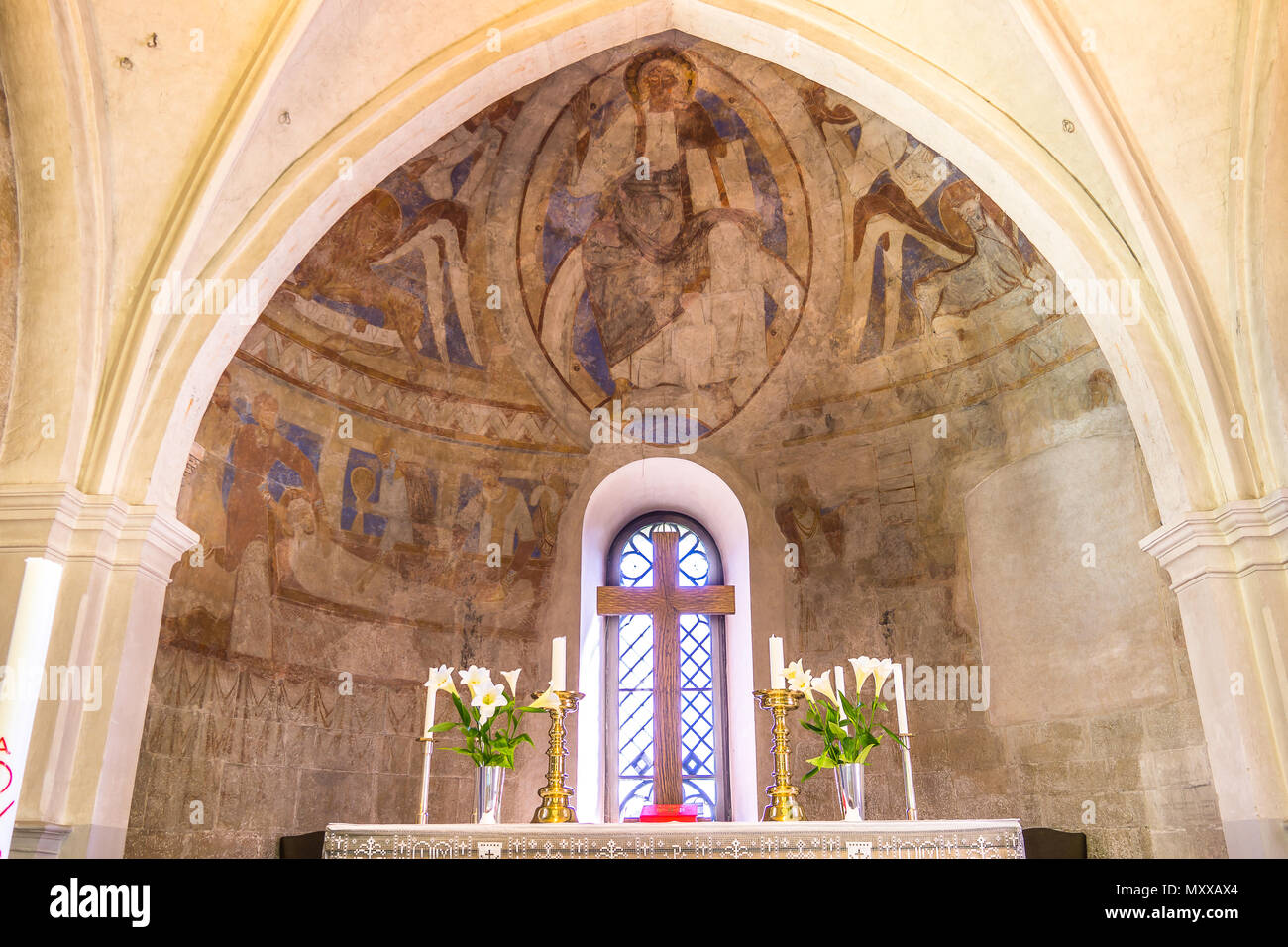 The altar and apse with christ pantocrator, majestas domini, sitting on the rainbow, Romanesque mural in Vinslov church, Sweden, May 9, 2018 Stock Photo