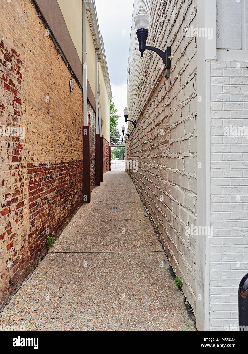Simple quiet narrow city or urban alley way with high brick walls in Auburn Alabama, USA. Stock Photo