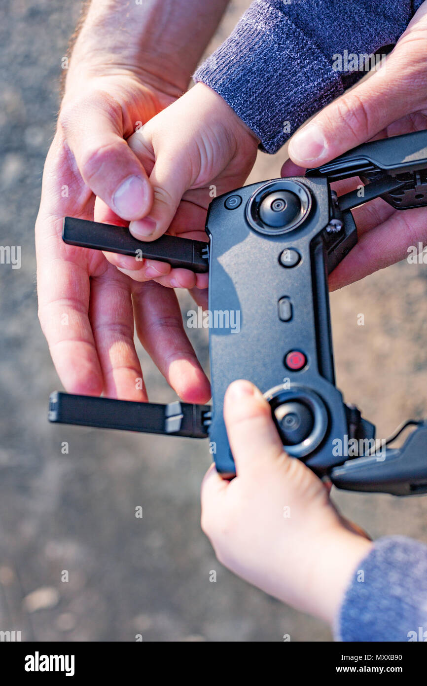 Father and son looking at remote control joystick and piloting ...