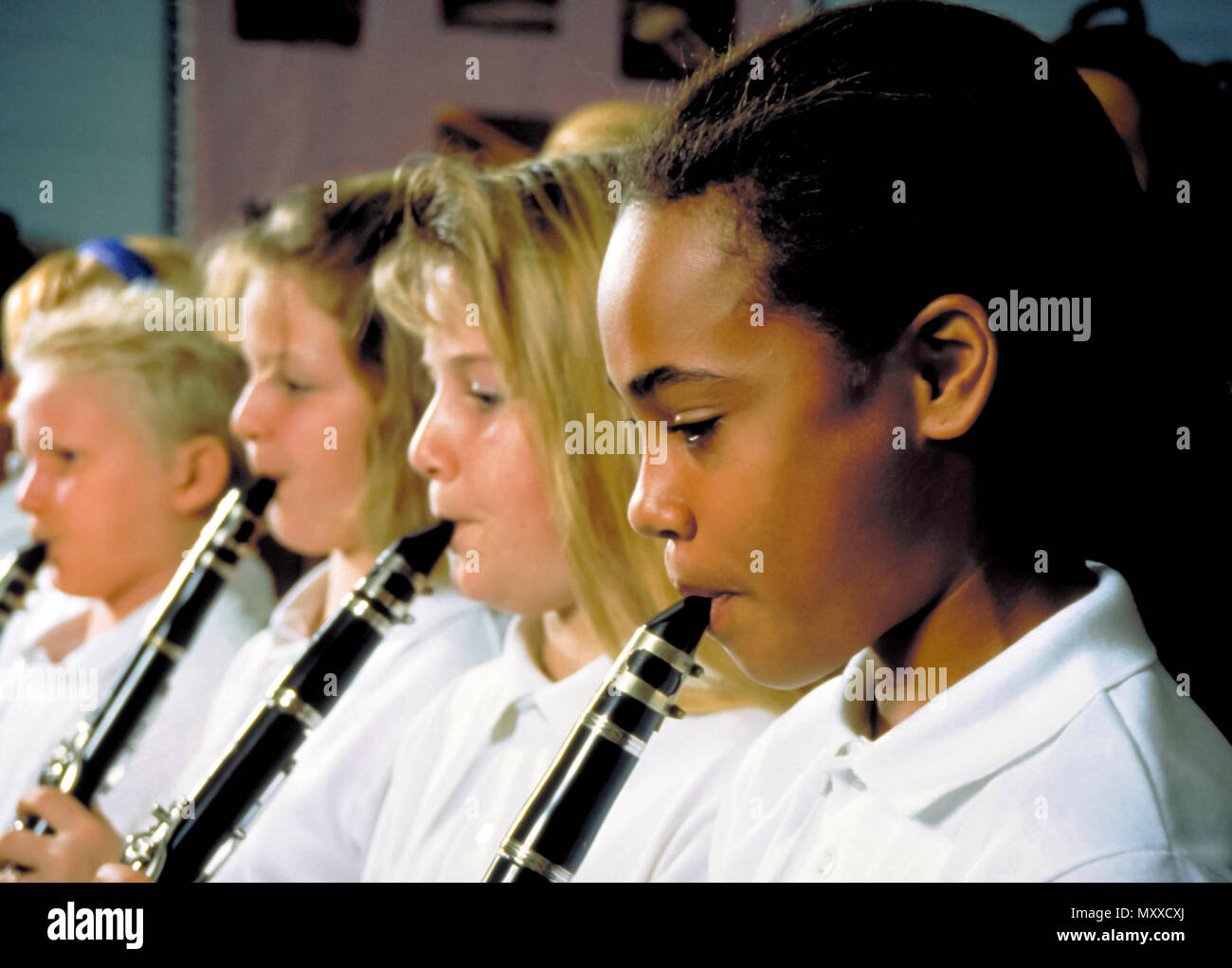 Children playing clarinets in band room at school. Stock Photo