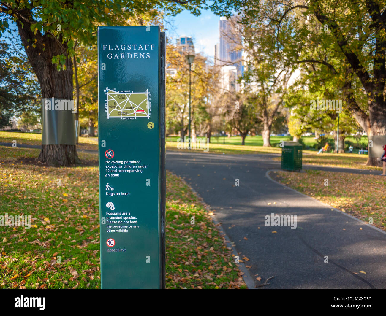 Sign and footpath of Flagstaff Gardens in Melbourne city. Map, rules and instructions on sign: No cycling; Dog must be on a leash. VIC Australia. Stock Photo