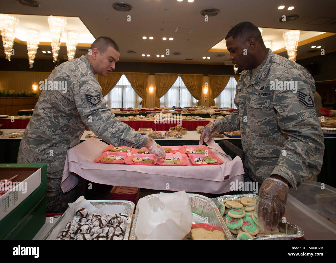 U.S. Air Force Staff Sgt. Robert Smalling, left, the 35th Medial Operations Squadron immunizations NCO in charge, and Tech. Sgt. Johnnie Powell, right, the 35th Force Support Squadron readiness and mortuary affairs NCO in charge, divide cookies during the annual Cookie Caper event at Misawa Air Base, Japan, Dec. 7, 2016. Volunteers gave more than 14,400 home-baked cookies to the event, while others donated dough to be cooked. (U.S. Air Force photo by Senior Airman Deana Heitzman) Stock Photo
