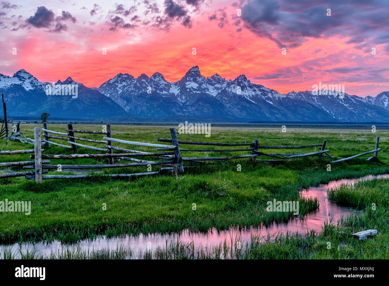 Teton On Fire - A spectacular spring sunset at Teton Range, seen from an abandoned old ranch in Mormon Row, in Grand Teton National Park, Wyoming, USA. Stock Photo