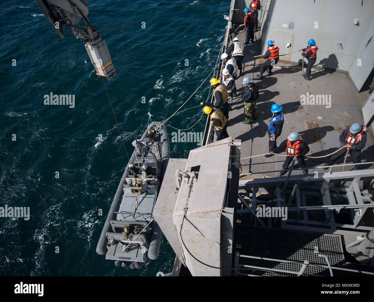 A Knuckle-boom Crane Lowers A Rigid Hull Inflatable Boat Aboard Uss 