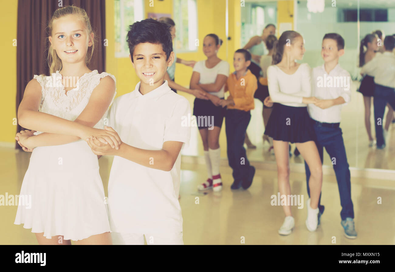 Group of positive smiling spanish children dancing salsa in school