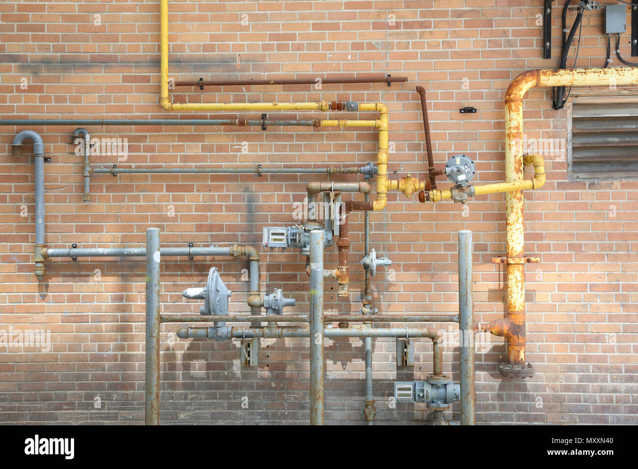 Copper pipes on a brick wall Stock Photo