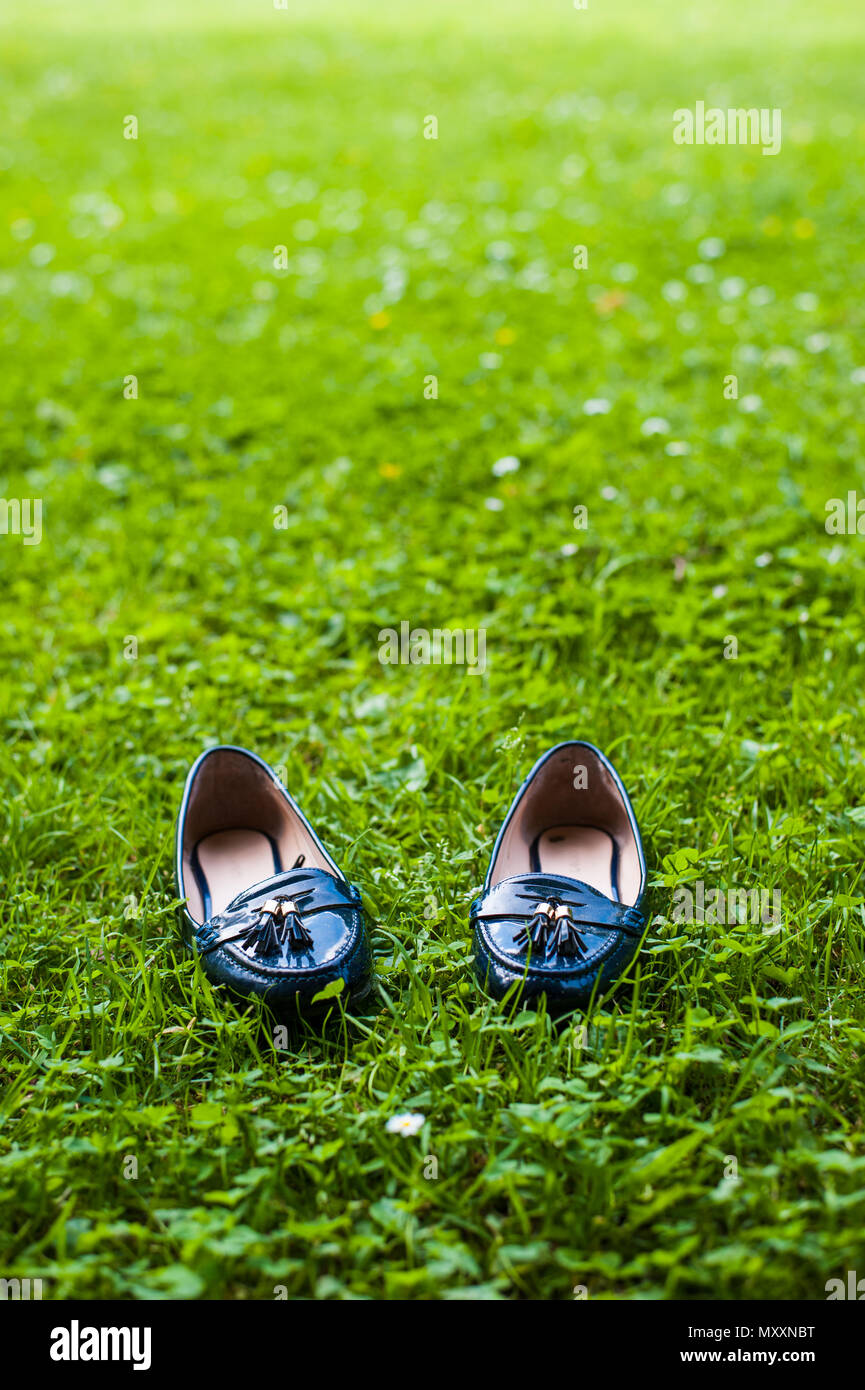 Blue girl's patent leather shoes on grasses Stock Photo