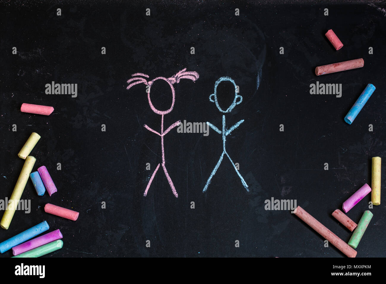 colored chalks on a black blackboard with the drawings of little girl