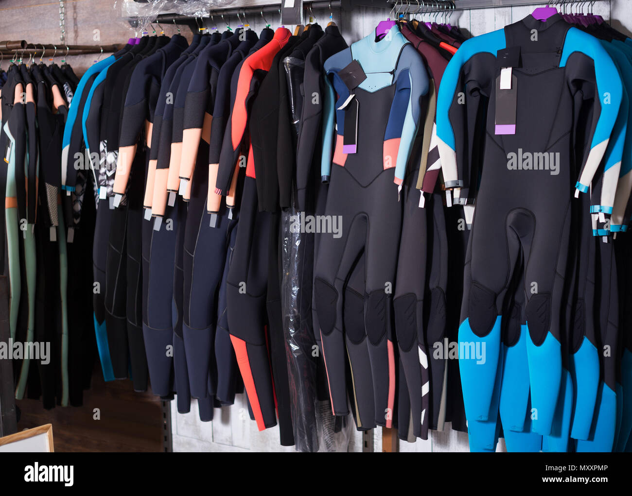 Image of colorful wetsuit hanging in the modern spanish store for