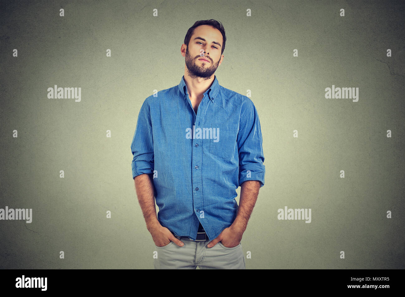 Arrogant self confident man in high self esteem standing with hands in pockets looking at camera Stock Photo