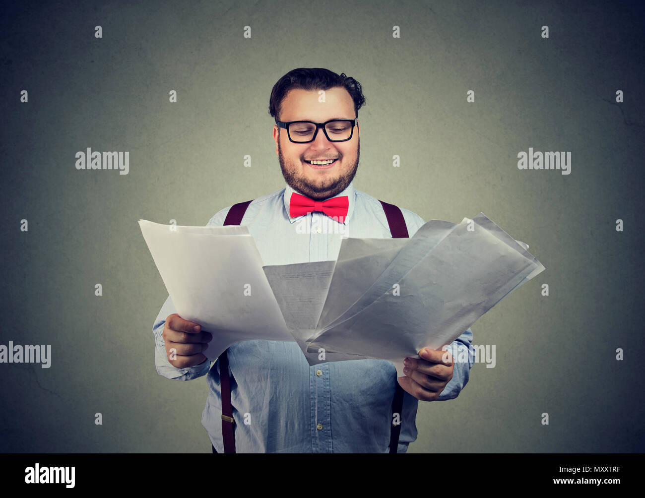 Happy business man in glasses holding pile of documents and looking excited with results of application Stock Photo